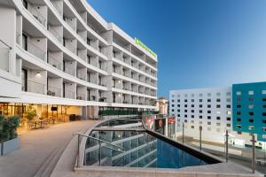 a hotel with a walkway in front of a building at Wyndham Garden Mazatlan Marina in Mazatlán