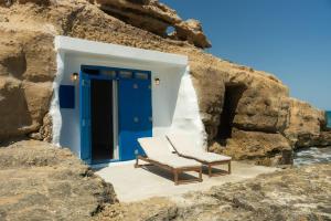 a chair sitting in front of a blue door at Thavma Beach House in Mytakas +3 photos