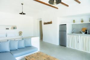 a living room with a blue couch and a kitchen at Thavma Beach House in Mytakas