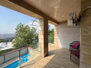 a patio with a pool and chairs on a balcony at Villa in Norq -Marash in Yerevan
