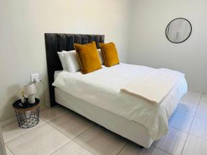 a bedroom with a large white bed with yellow pillows at 3 on Eland in Vryheid