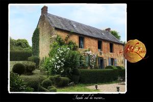 a large brick building with bushes and flowers in front of it at Manoir de Livet in Saint-Germain-de-Livet +11 photos