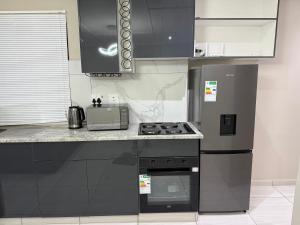 a kitchen with a stove and a refrigerator at 3 on Eland in Vryheid