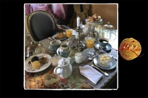 a table filled with dishes and cups and a plate of food at Manoir de Livet in Saint-Germain-de-Livet