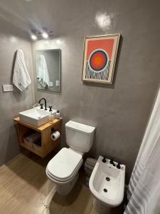 a bathroom with a white toilet and a sink at Petit BANFIELD in Banfield
