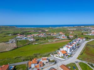 an aerial view of a village with houses and the ocean at Torres Vedras House in Silveira