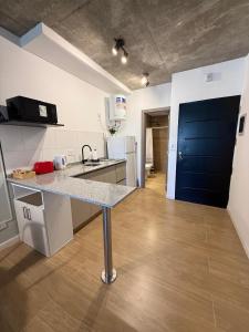 a kitchen with a counter and a blue door at Petit BANFIELD in Banfield +15 photos