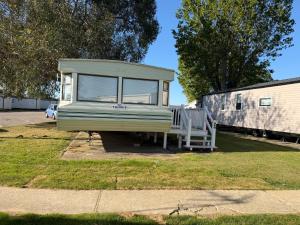 a tiny house is parked in a yard at Jackson Home from Home Holidays in Little Clacton +8 photos