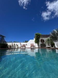 a swimming pool with two chairs in a resort at Casa Calango suites in Fortim