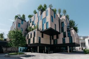 ein Gebäude mit einem Baum auf dem Dach in der Unterkunft Ruby Ella Hotel Cologne by IHG in Köln