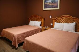 ein Hotelzimmer mit zwei Betten und einem Bild an der Wand in der Unterkunft Hotel Colonial in Monterrey