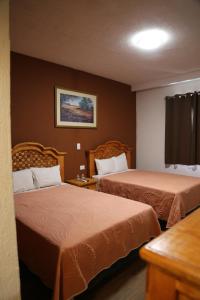 ein Zimmer mit zwei Betten in einem Hotelzimmer in der Unterkunft Hotel Colonial in Monterrey