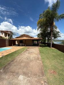 a house with a palm tree and a yard at Rancho Renato Chaveiro in Capitólio