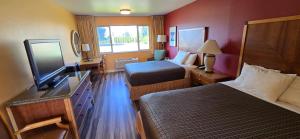 ein Hotelzimmer mit zwei Betten und einem Flachbildfernseher in der Unterkunft Olympic View Inn in Sequim