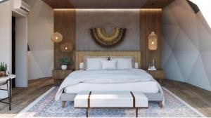 a bedroom with a king sized bed with a large white bedspread at Vilodge in Charrúa