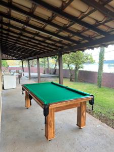 a green pool table sitting under a pavilion at Rancho Renato Chaveiro in Capitólio