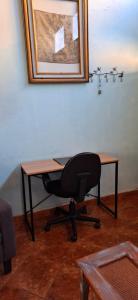 a desk with a chair and a picture on the wall at CHIK Coatepec Comfort in Coatepec
