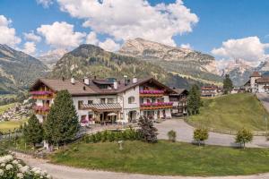 a large building with mountains in the background at Hotel Chalet Dlaces in Selva di Val Gardena