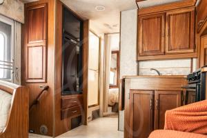 a small kitchen with wooden cabinets and a sink at MUUN experience in Ciudad del Carmen