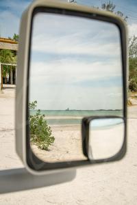 a view of the beach from a car side view mirror at MUUN experience in Ciudad del Carmen