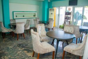 a dining room with tables and chairs and blue walls at NI-FUR Hotel Cotonou in Cotonou