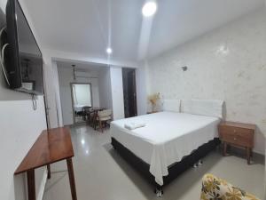 a bedroom with a bed and a table and a television at Hotel Betania in Jaén
