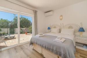 a bedroom with a bed and a large window at Vila Vista Luz in Lagos