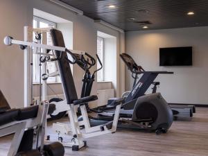 a gym with two tread machines and a flat screen tv at Blooma Hotel Liege Centre - Accor Handwritten Collection in Liège