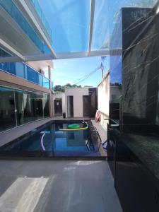 a swimming pool in the middle of a house at Terraço Hostel in Cabo Frio