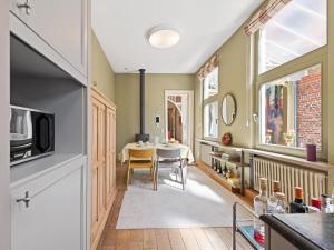 a kitchen and dining room with a table and chairs at La Maison Bleue petite in Ronse