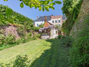 an alley in a garden with a building at La Maison Bleue petite in Ronse