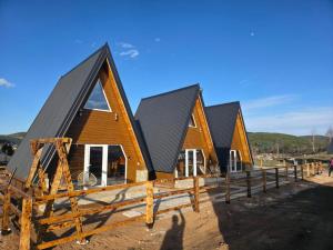 a row of houses under construction with a wooden fence at Mountain Houses Jakov in Žabljak