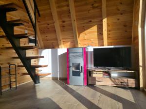 a living room with a large television in a cabin at Mountain Houses Jakov in Žabljak