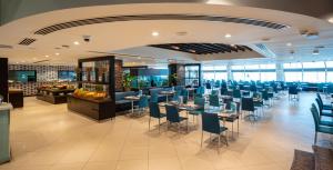 a dining room with tables and chairs in a restaurant at Occidental Sharjah Grand in Sharjah