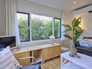a living room with a desk and a large window at Chalet Sea Birds in Goedereede