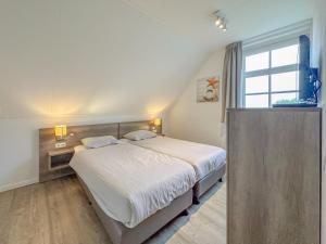 a bedroom with a large bed and a window at Dune Design 38 in Colijnsplaat