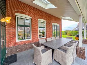 a patio with a table and chairs and a brick wall at Dune Design 38 in Colijnsplaat