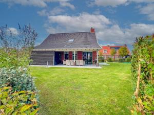 a house with a green yard with a house at Dune Design 38 in Colijnsplaat