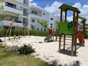 a playground in the sand in front of a building at Private Beach Community - White Sands Golf Resort - Modern 2BR Private Pool and Patio in Punta Cana