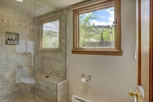 a bathroom with a shower with a window and a glass door at Beaver Creek Village by Vail Resorts in Avon +55 photos