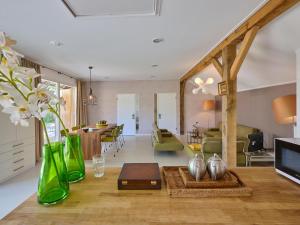 a living room with green glass vases on the floor at Twente Village in Haaksbergen