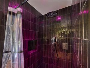 a purple tiled bathroom with a shower with purple lights at Twente Village in Haaksbergen +60 photos