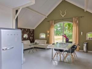a living room with a refrigerator and a table at Twente Village in Haaksbergen
