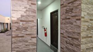 a brick wall with a door and a fire extinguisher at Malbon Green Executive Plus Lodge in Kafue +2 photos