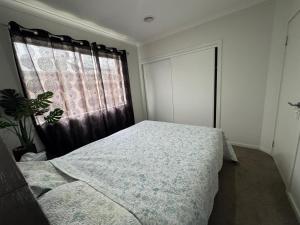 a bedroom with a bed and a window at Cozy and comfortable room - Geelong suburbs in Grovedale