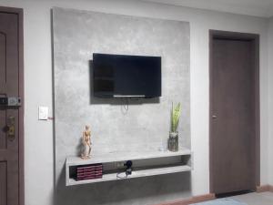 a living room with a tv on a wall at Recanto dos Querubins in Cambé
