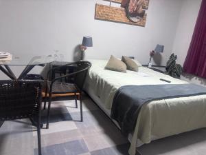 a bedroom with a bed and a table and chairs at Recanto dos Querubins in Cambé