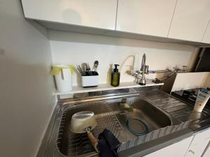 a kitchen sink with a person reaching into it at Stay GaeBong in Seoul