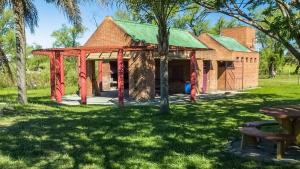 a building with red curtains in a park at Cabañas Las Macluras in Colastiné