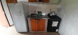 a small kitchen with a refrigerator and a sink at Cabañas Las Macluras in Colastiné